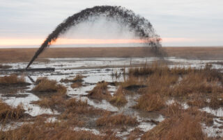 Sediment is sprayed onto marsh. Dave Harp